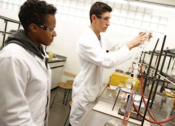 Zwei Chemisch-Technische Assistenten (CTAs) experimentieren mit chemischen Stoffen.