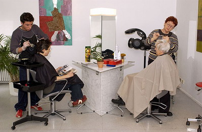 Ein Friseur schneidet die Haare eines Kunden.