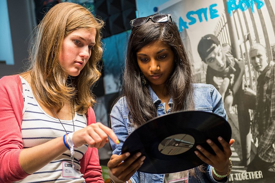 Zwei Jugendliche schauen sich eine Vinyl-Platte an.