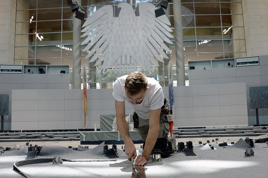 Ein Mann arbeitet am Boden des Deutschen Bundestags.