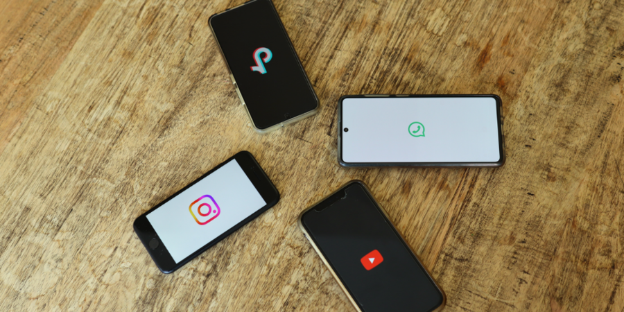 Vier Handys zeigen jeweils ein Icon einer populären Social Media App.