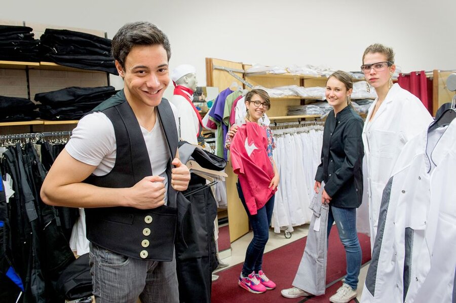 Vier Jugendliche mit unterschiedlichen Kleidungsstilen shoppen in einem Bekleidungsgeschäft.